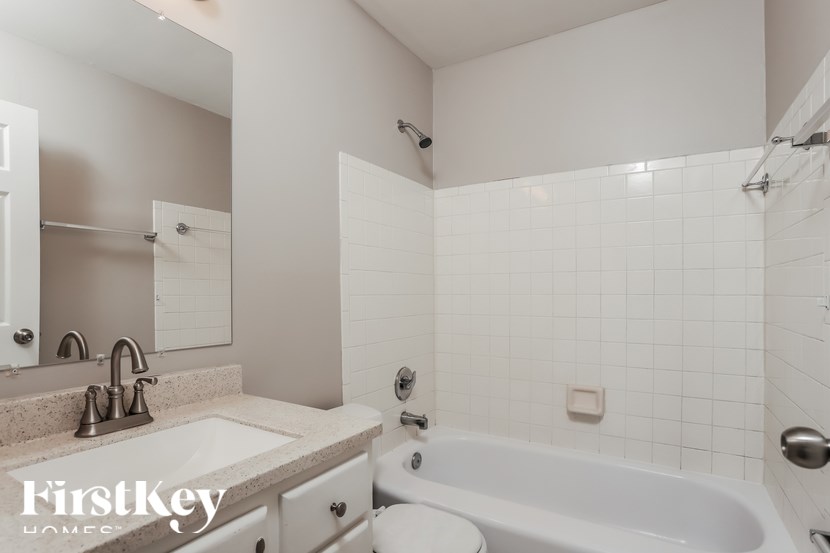 A white bathroom with a tub, sink, and toilet.