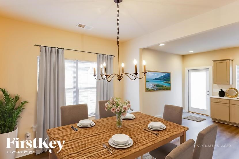 A dining room with a wooden table set for four.