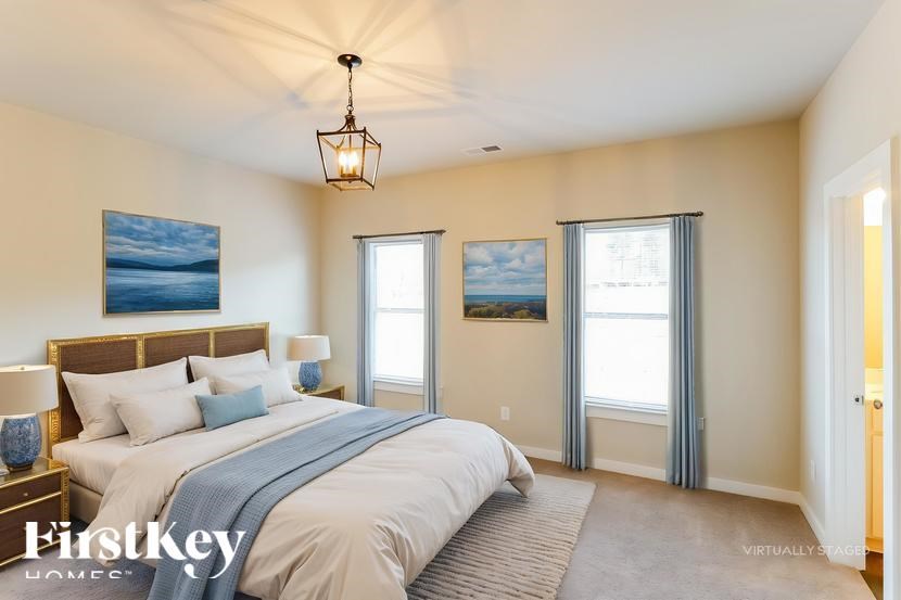 A bedroom with a large bed and a painting on the wall.