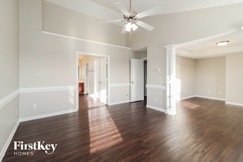 a living room with hardwood flooring and a ceiling fan