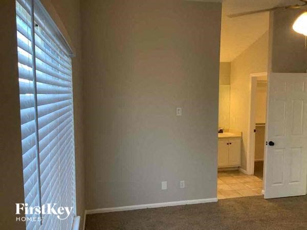 an empty living room with a door to a bathroom