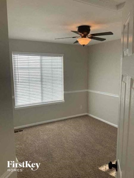 an empty room with a ceiling fan and a window