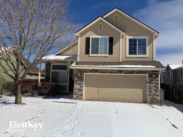 a house with a garage in the snow