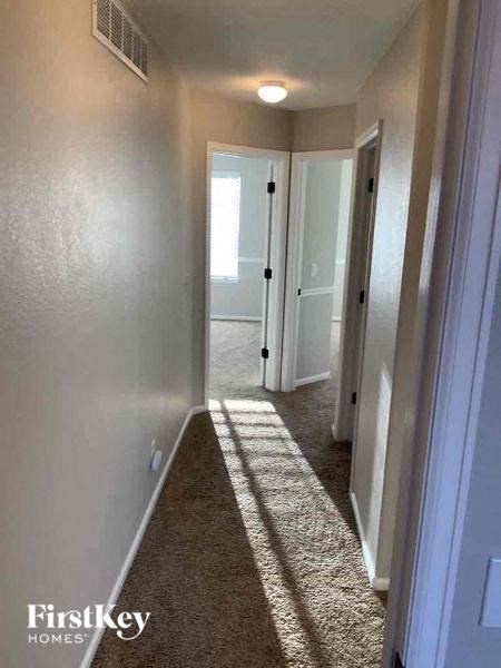 a hallway with a carpeted floor and a door to a closet