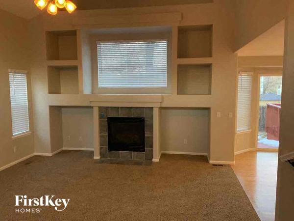 a living room with a fireplace and shelves