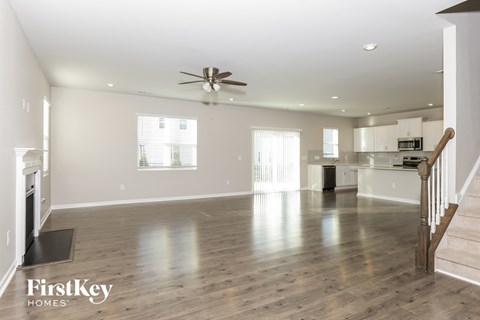 A spacious living room with a staircase on the right side.