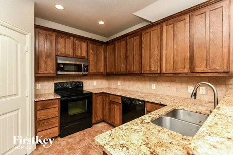 a kitchen with black appliances and granite counter tops