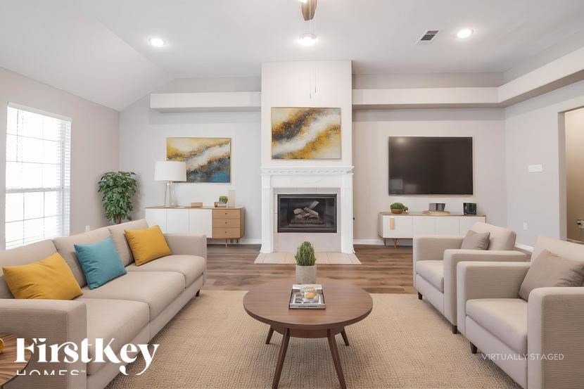 A virtual staged living room with a fireplace and a painting on the wall.