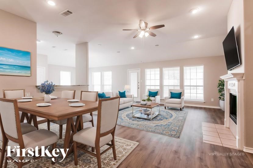 A well-lit, spacious dining room with a wooden table and chairs.