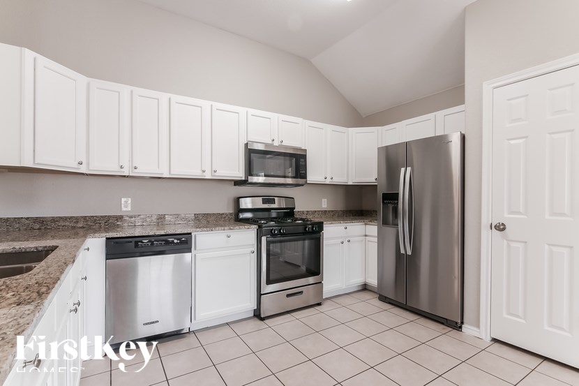 A kitchen with white cabinets and appliances.