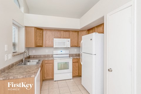 a kitchen with white appliances and wooden cabinets