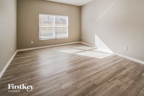the living room with hardwood flooring and a window