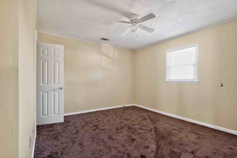 A room with a ceiling fan and a window.