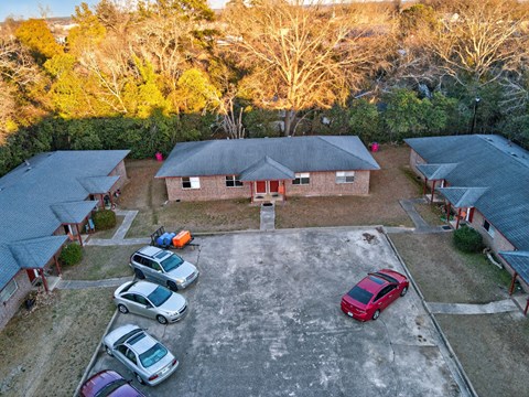 A parking lot with several cars and a building in the background.