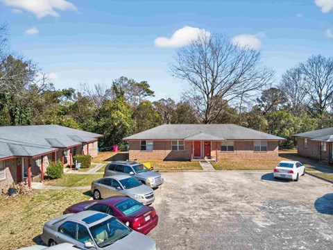 A parking lot with several cars and a building in the background.