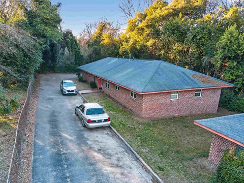 A house with a red roof and a car parked in front.