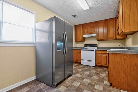 A kitchen with a refrigerator, stove, and sink.