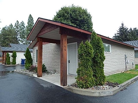 a small building with a covered parking lot