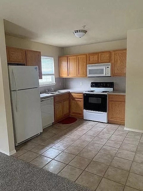 a kitchen with white appliances and wooden cabinets