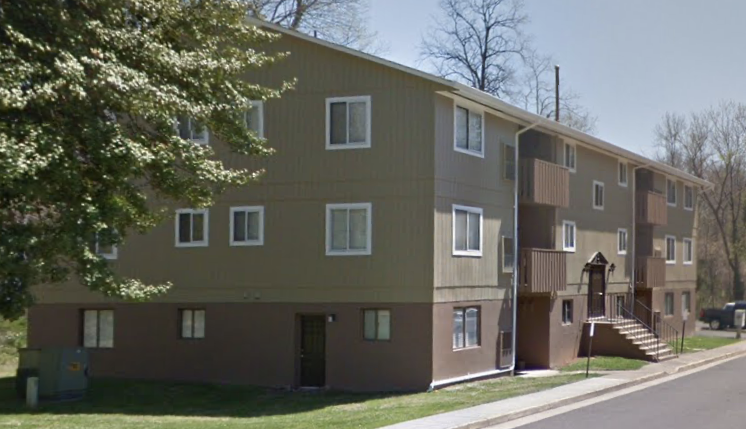an apartment building with a tree in front of it
