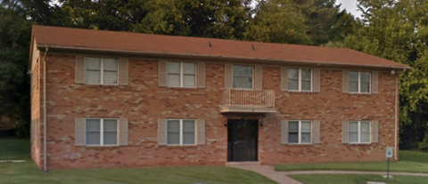an old brick building with a balcony and a black door