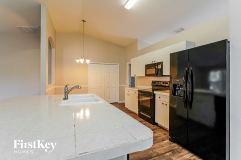 a kitchen with black appliances and a white counter top