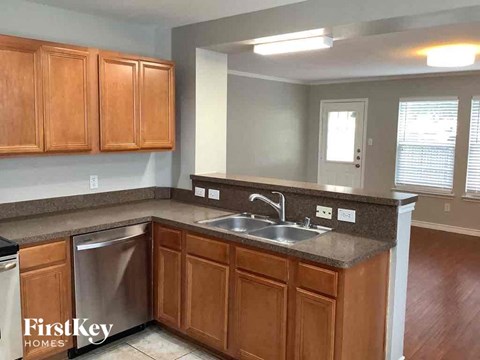A kitchen with wooden cabinets and a stainless steel dishwasher.