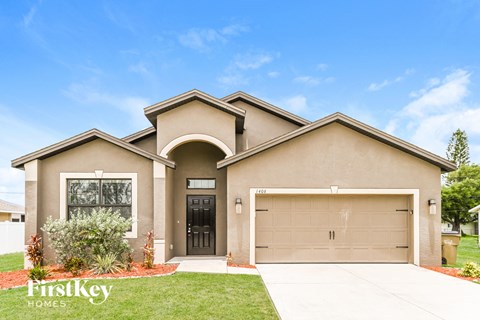A house with a garage and a driveway in front of it.