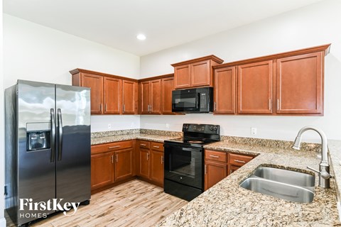 A kitchen with wooden cabinets and a granite countertop.