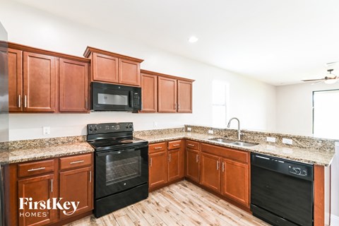 A kitchen with wooden cabinets and black appliances.