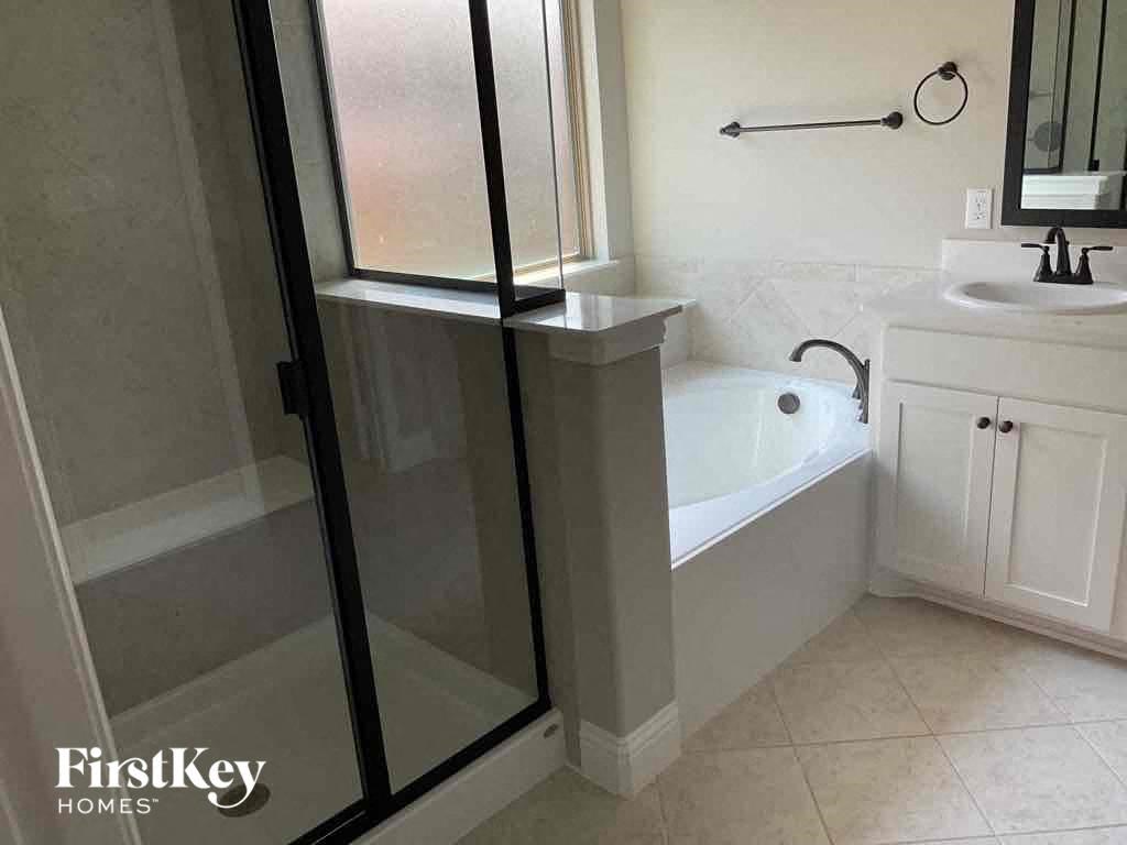 a bathroom with a shower and a sink and a tub