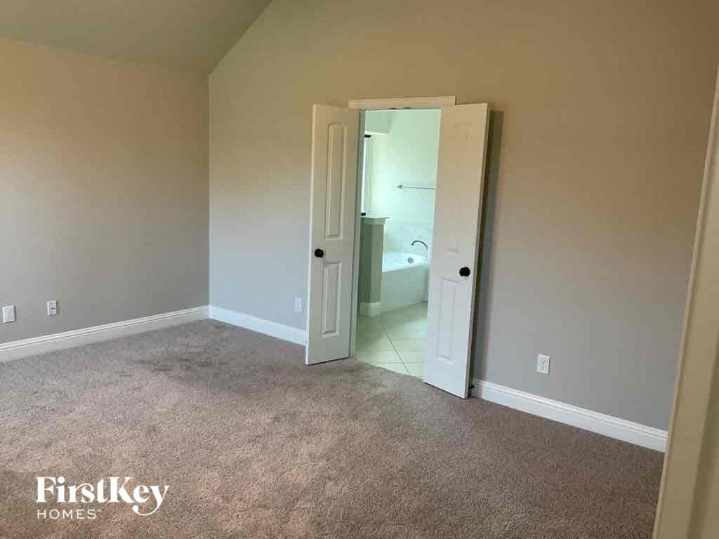 an empty living room with a door open to a bathroom