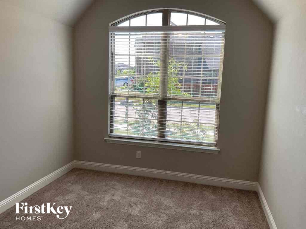 an empty room with a large window and a carpet