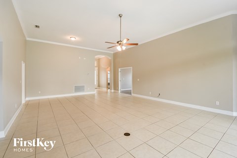 A spacious room with a ceiling fan and tiled flooring.