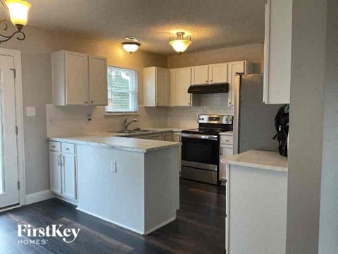 a kitchen with white cabinets and a stove and a refrigerator