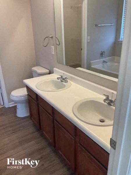 a bathroom with two sinks and a toilet and a mirror
