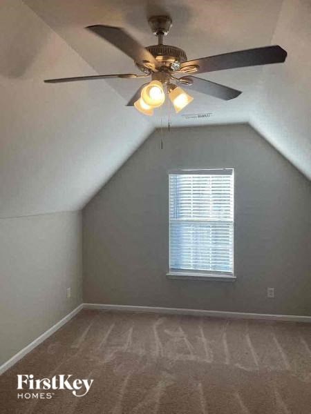 an empty room with a ceiling fan and a window