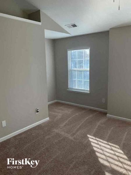 an empty room with a window and a carpet