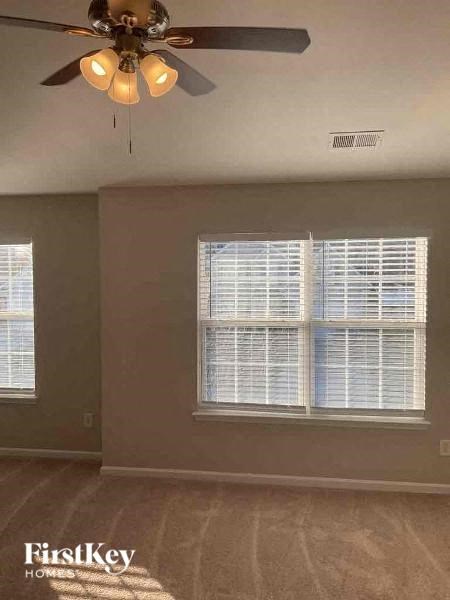 an empty living room with a ceiling fan and a window
