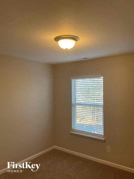 an empty room with a window and a ceiling light