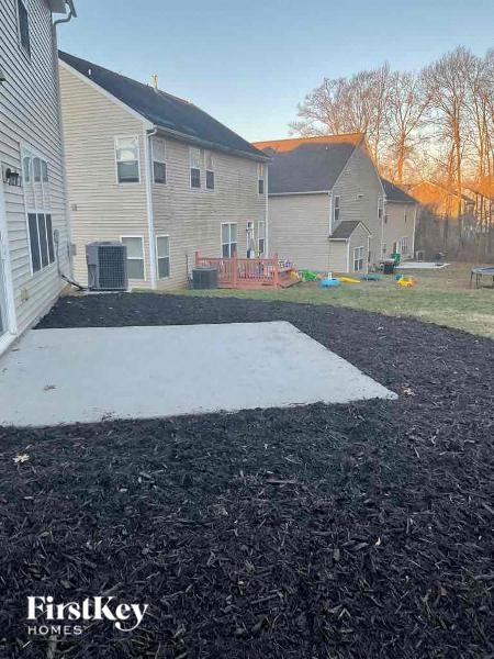 a yard with a concrete slab in front of a house