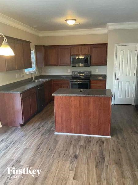 a kitchen with wooden floors and a stove and cabinets