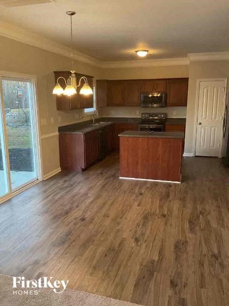 a kitchen with a wooden floor and wooden cabinets