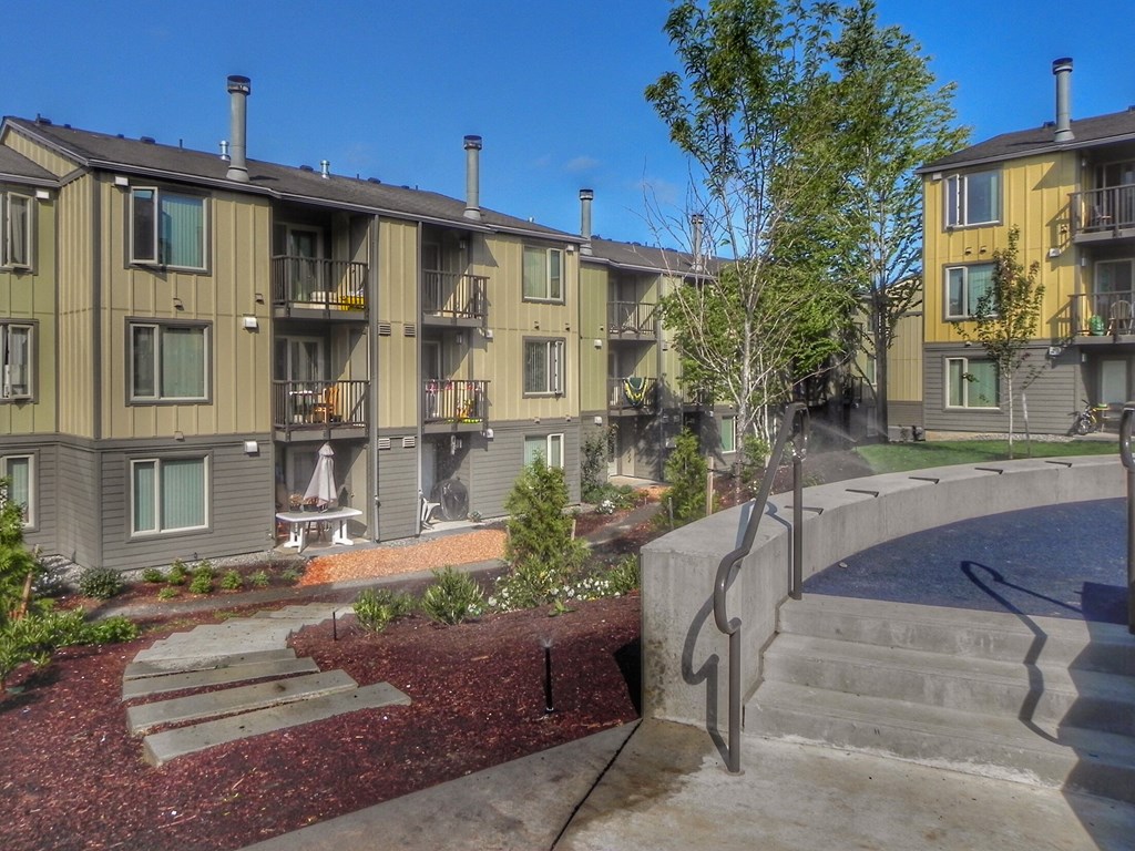 an exterior view of an apartment building with stairs and a courtyard