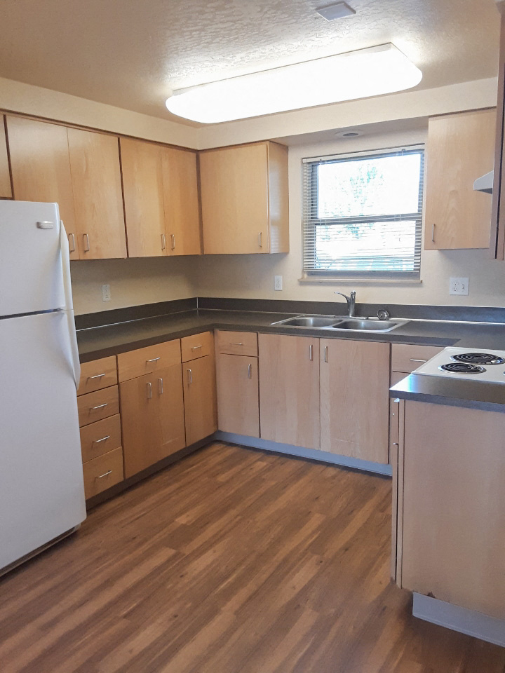 A kitchen with wooden cabinets and a white refrigerator.