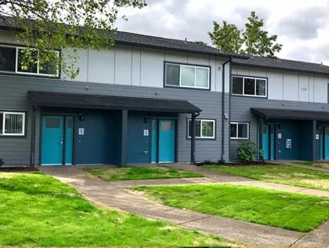 a building with blue doors and a green lawn