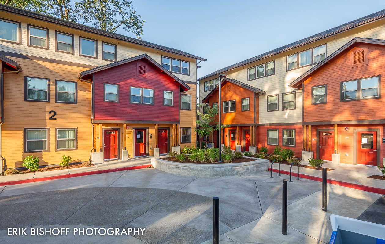 a group of houses with red and yellow doors and a courtyard
