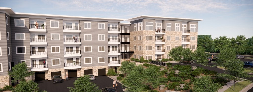 an aerial view of an apartment building with trees and a parking lot
