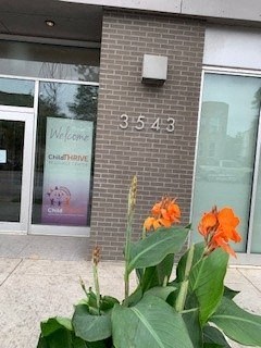 the front of a building with orange flowers