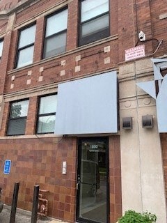 the front of a brick building with a glass door